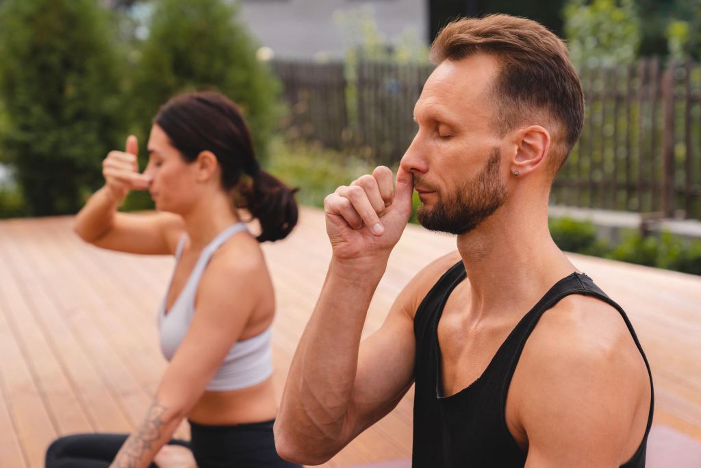 Close up photo of two caucasian yogi breathing deeply with one nostril during yoga class